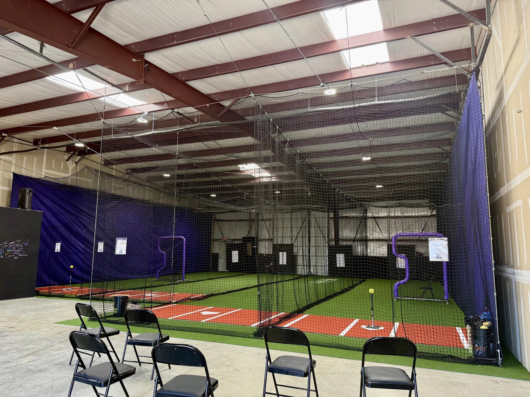 Batting cages and turf inside Velocity Fastpitch Academy's indoor facility