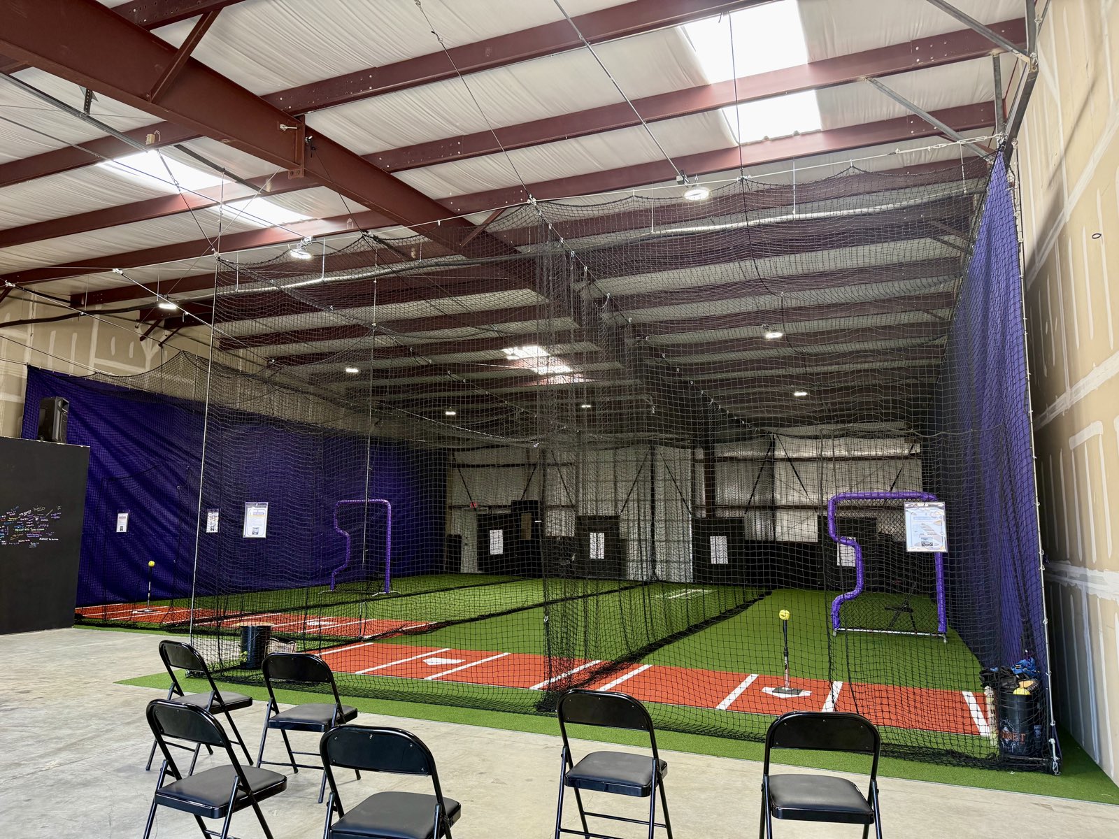 Batting cages and turf inside Velocity Fastpitch Academy's indoor facility