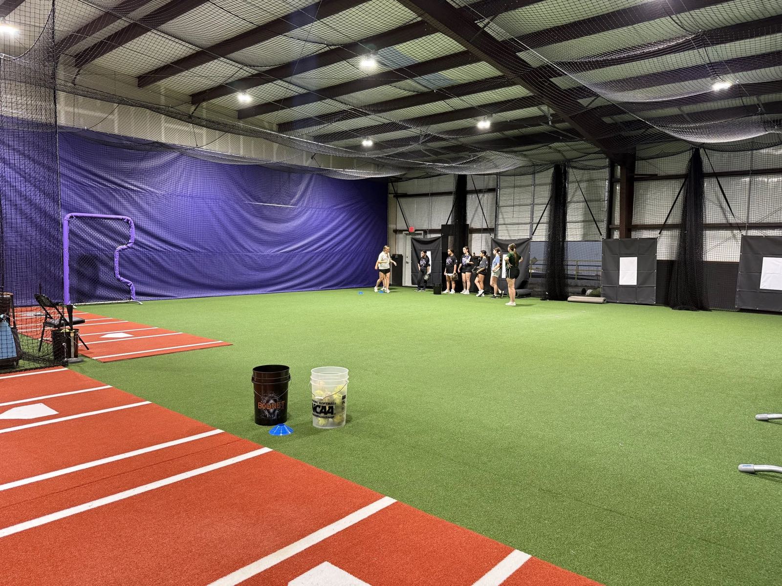 Indoor turf training area with batting cages at Velocity Fastpitch Academy in Alvarado, Texas